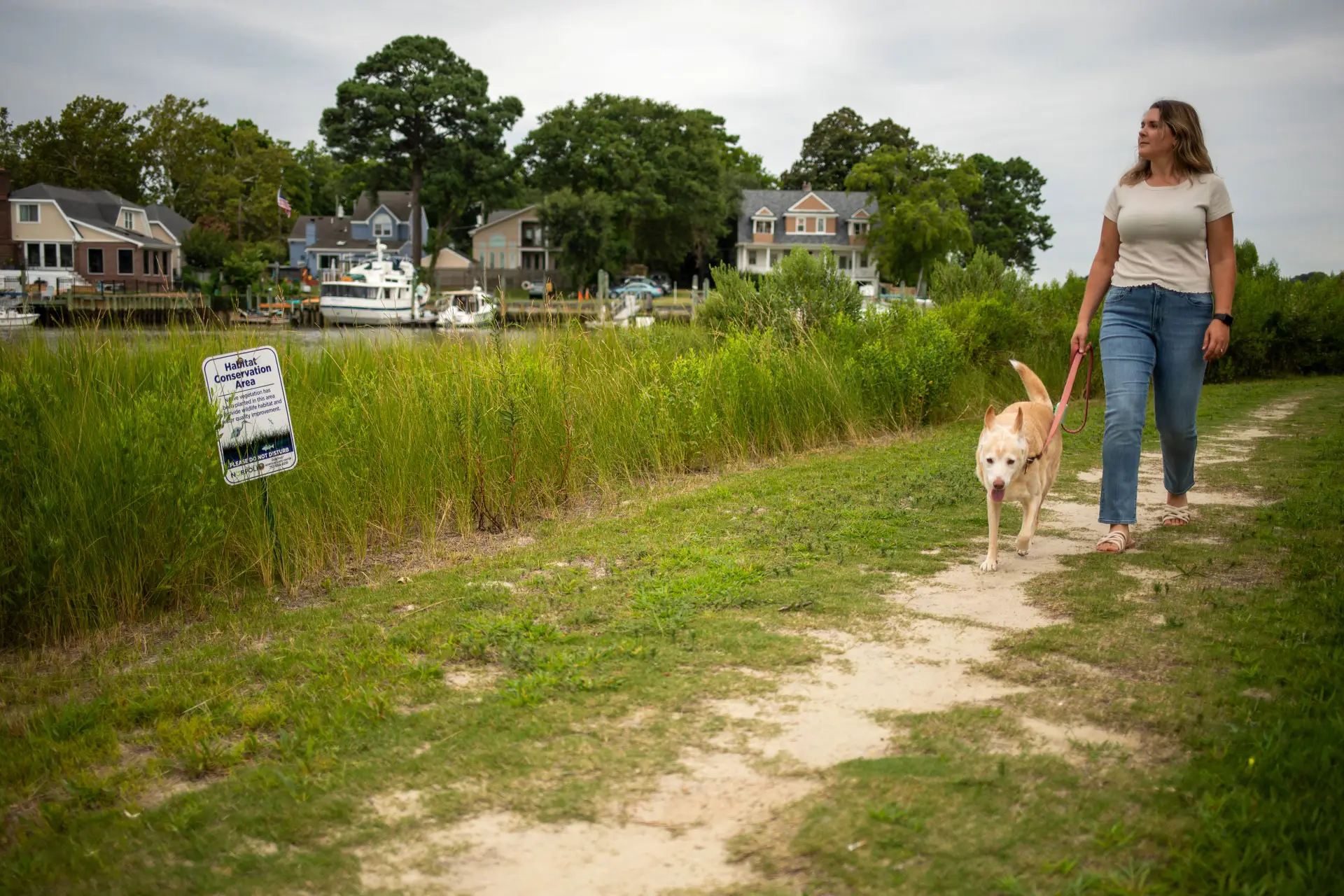A woman and her dog walking in the Knitting Mill Creek area of Norfolk