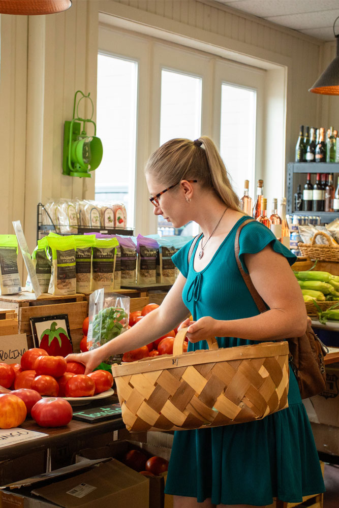 Local resident shopping for vegetables inside Westside Produce & Provisions
